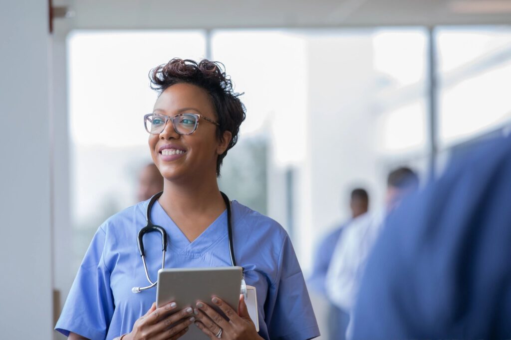Clinician holding a tablet in a hospital hallway